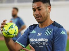 Óscar Opazo con un balón en la mano mientras realiza los ejercicios precompetitivos con la camiseta de Racing Club de Avellaneda.