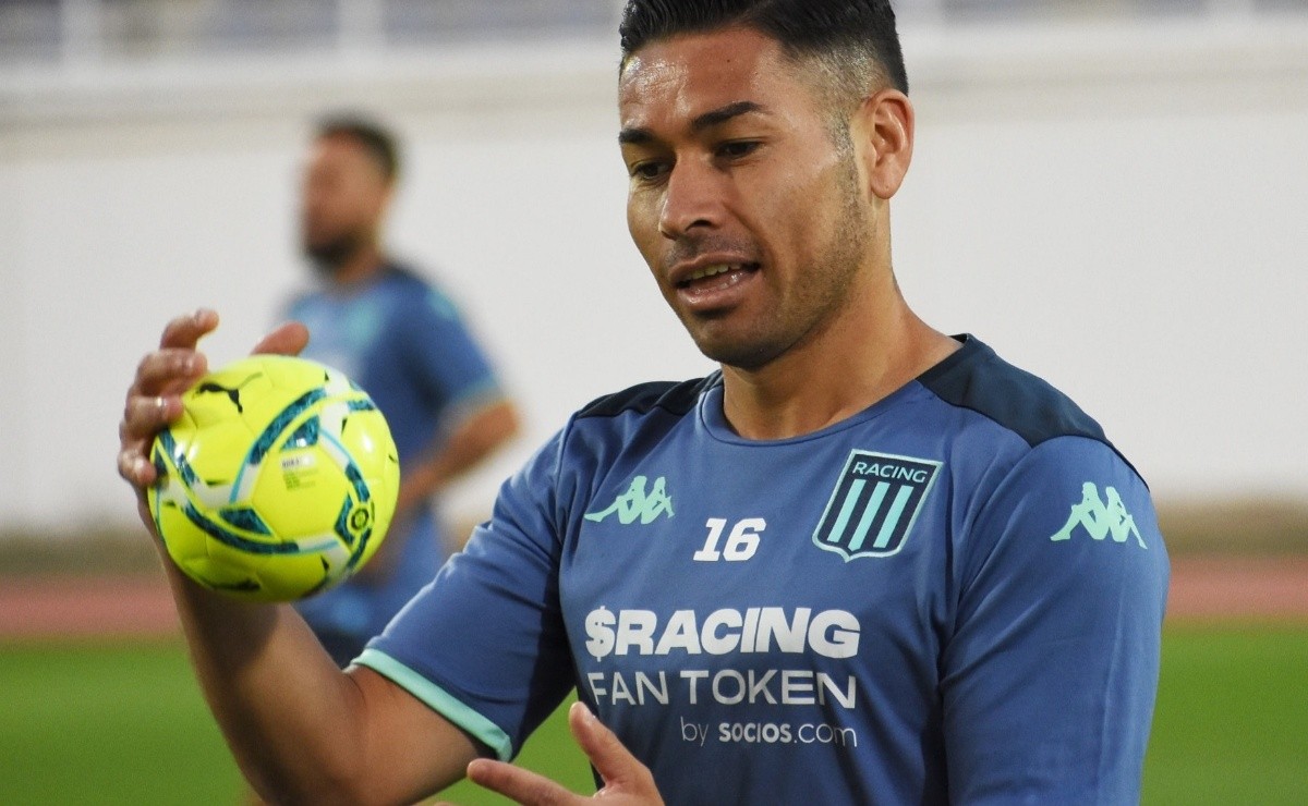 Óscar Opazo con un balón en la mano mientras realiza los ejercicios precompetitivos con la camiseta de Racing Club de Avellaneda.