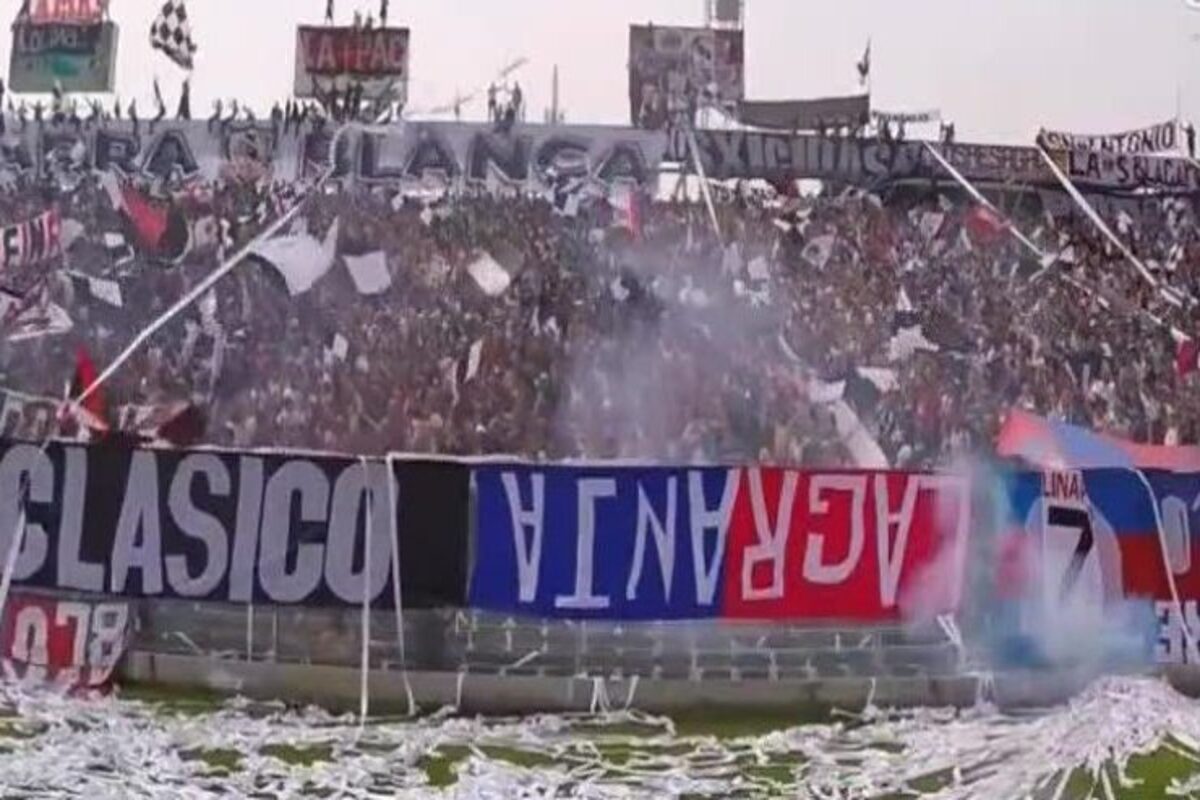 Hinchas de Colo-Colo en el sector cordillera del Estadio Monumental, donde se puede observar un lienzo de la barra de Universidad de Chile al revés.