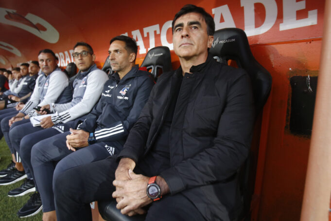 Gustavo Quinteros sentado en la banca de suplentes junto a su cuerpo técnico durante el empate 1-1 de Colo-Colo sobre Unión Española.
