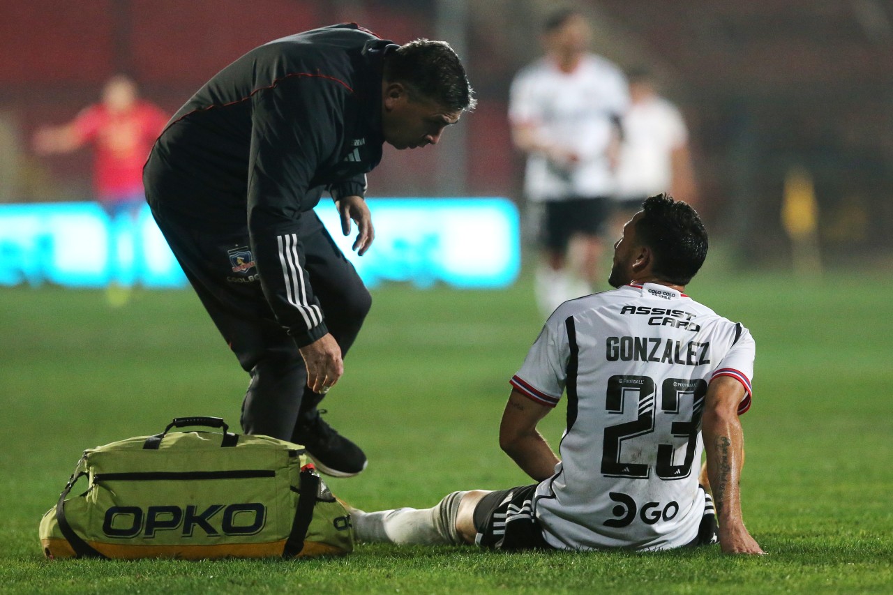 Ramiro González sentado siendo atendido por los médicos de Colo Colo