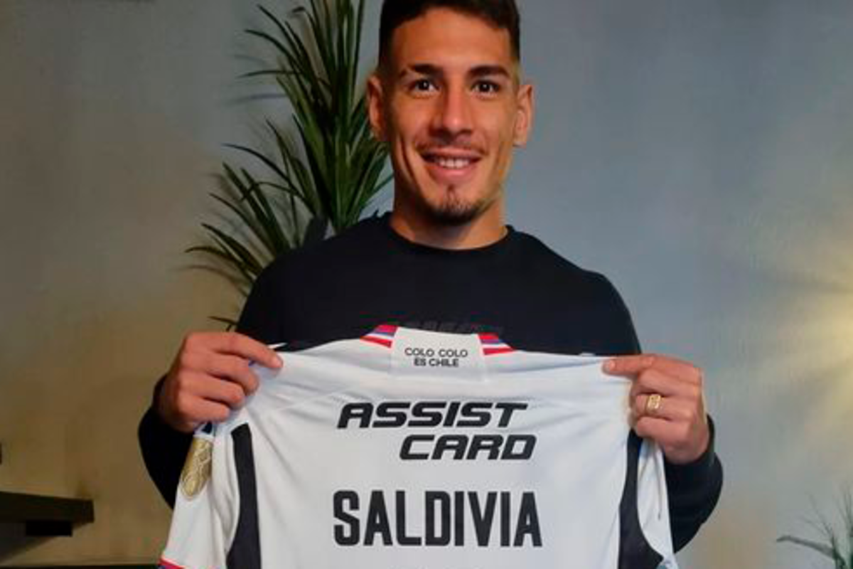 Alan Saldivia sosteniendo su camiseta de Colo-Colo, la cual donó para una rifa de la Ruta del Hincha.