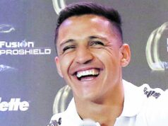 Primer plano a Alexis Sánchez sonriendo mientras entrega una conferencia de prensa con la camiseta del Olympique de Marsella.