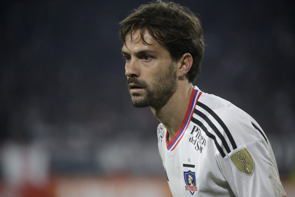 Agustín Bouzat defendiendo la camiseta de Colo-Colo y con la mirada fija a un rival en el duelo ante Boca Juniors por la Copa Libertadores 2023.