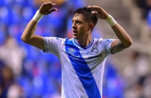 Pablo Parra mientras levanta las manos con la camiseta del Puebla