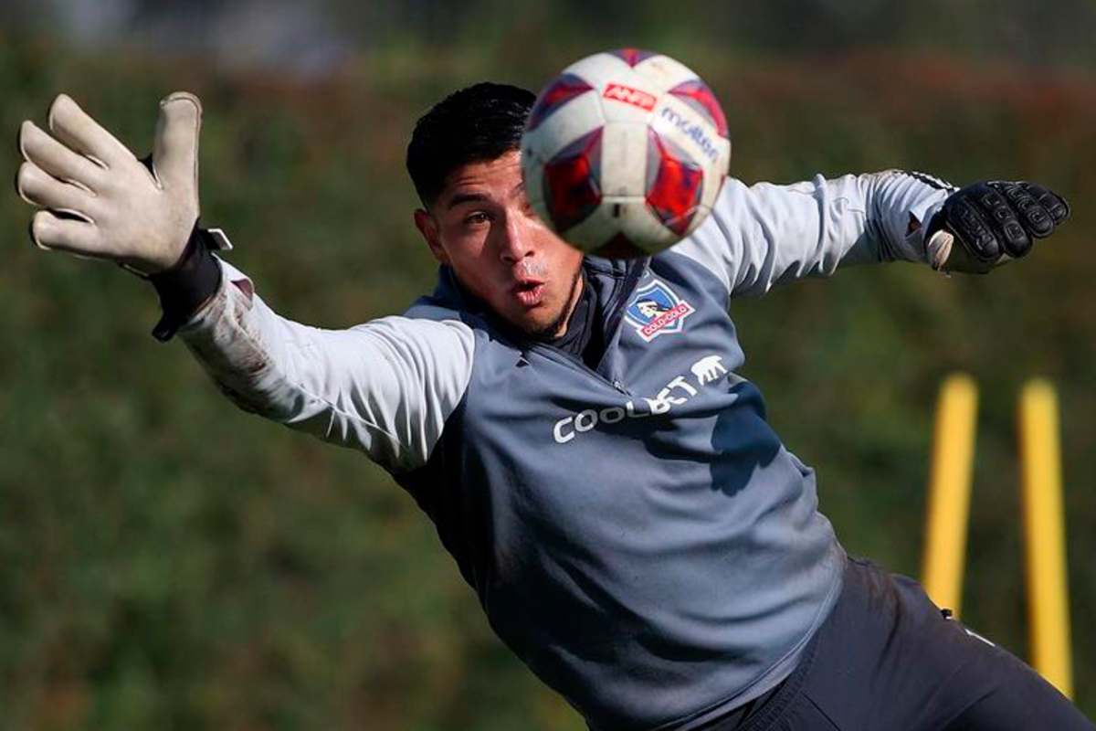 Brayan Cortés volando en el aire para atajar un balón en medio de un entrenamiento con la camiseta de Colo-Colo.