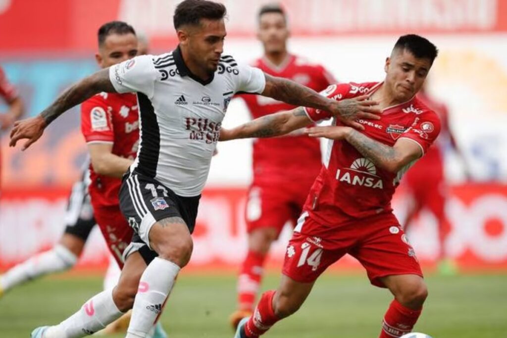 Marcos Bolados y Jovany Campusano tomándose de la camiseta en un partido de Colo-Colo y Ñublense