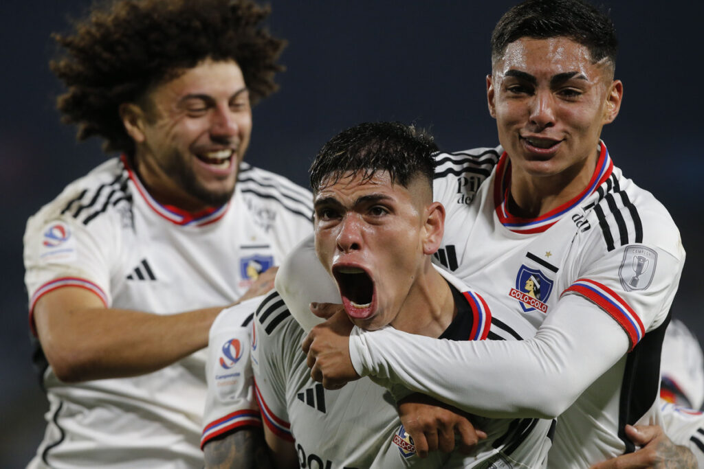 Jordhy Thompson y Maximiliano Falcón abrazan a Carlos Palacios, quien celebra eufórico un gol con la camiseta de Colo-Colo.