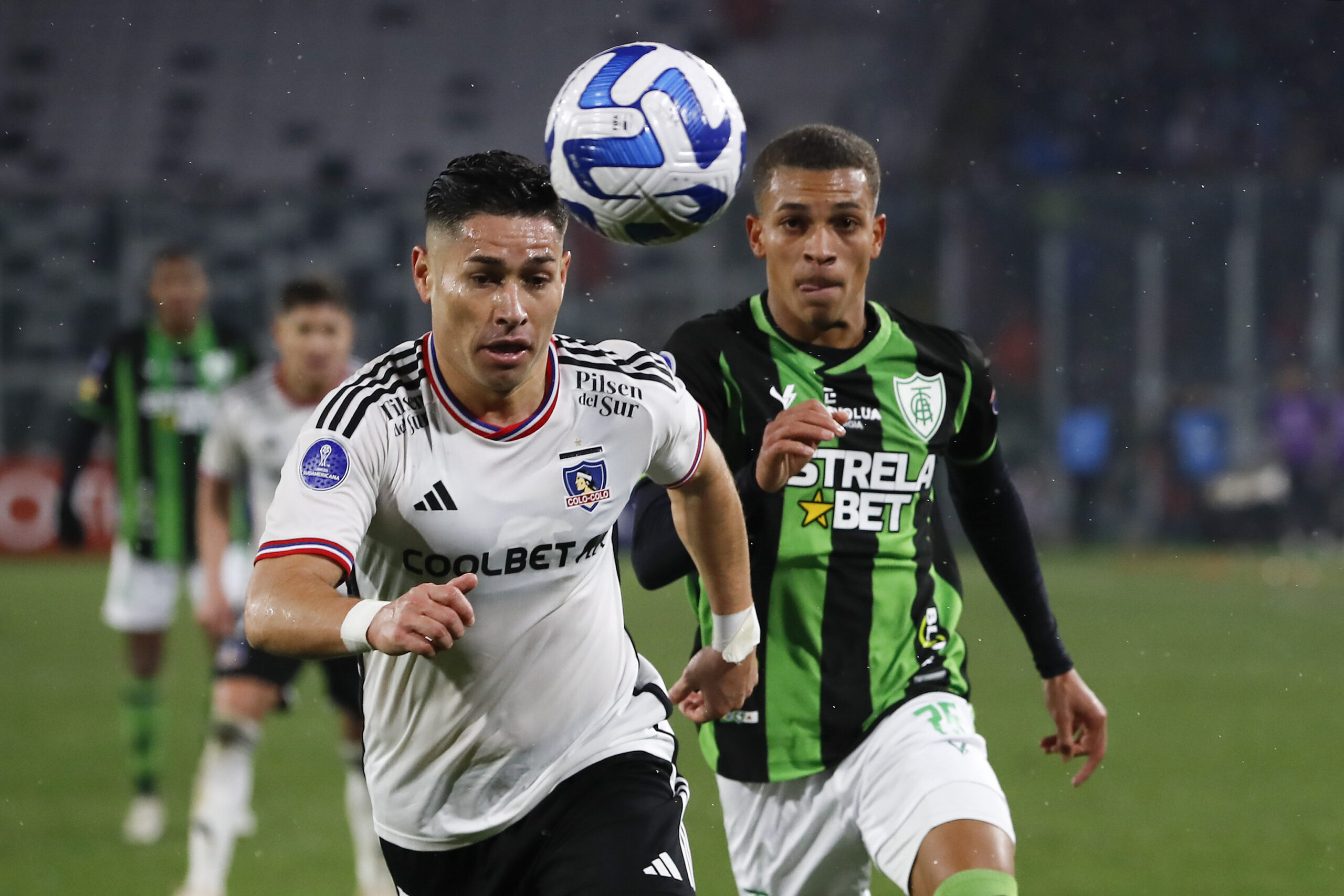 Óscar Opazo mirando el balón con jugador de América Mineiro atrás