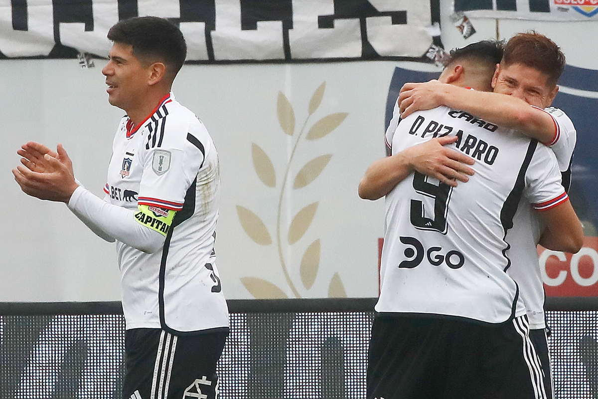 Leonardo Gil y Damián Pizarro se abrazan para celebrar el 2-0 parcial de Colo-Colo ante O'Higgins, mientras que Esteban Pavez los aplaude.