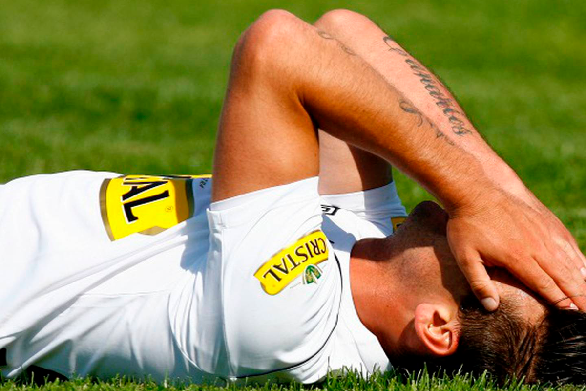 Roberto Gutiérrez en el suelo se tapa el rostro mientras defiende la camiseta de Colo-Colo.