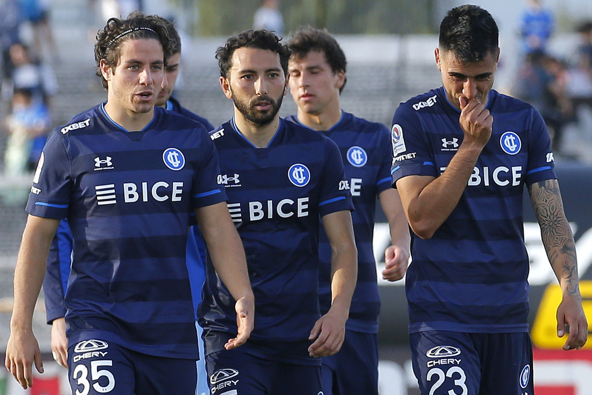 Jugadores de Universidad Católica tras disputar un partido se retiran pensativos del terreno de juego.