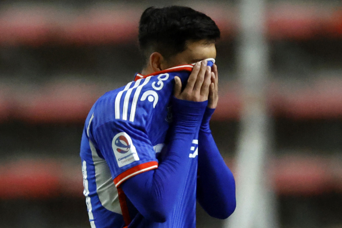 Jugador de Universidad de Chile tapándose la cara con la camiseta.