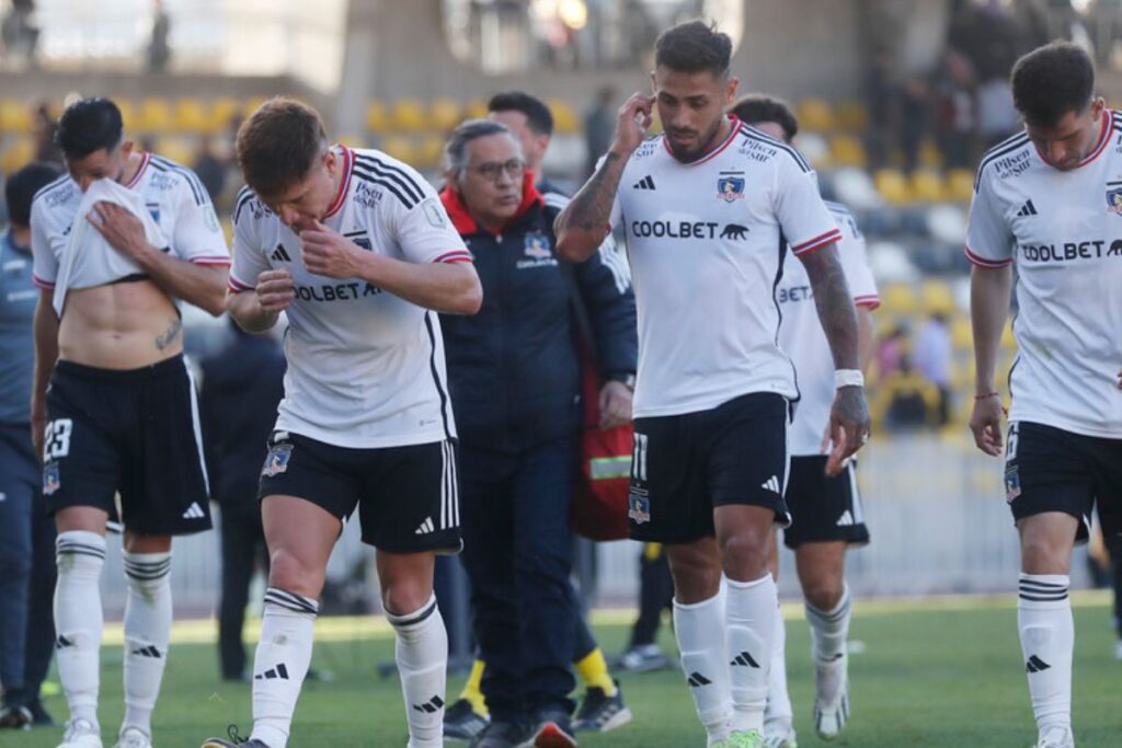 Futbolistas de Colo-Colo caminando en la cancha mientras usan la camiseta blanca