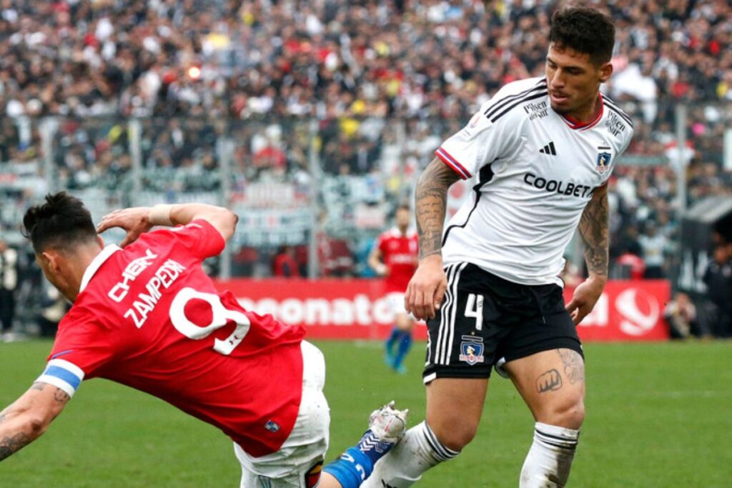 Alan Saldivia con camiseta blanca de Colo-Colo y Fernando Zampedri con la polera roja