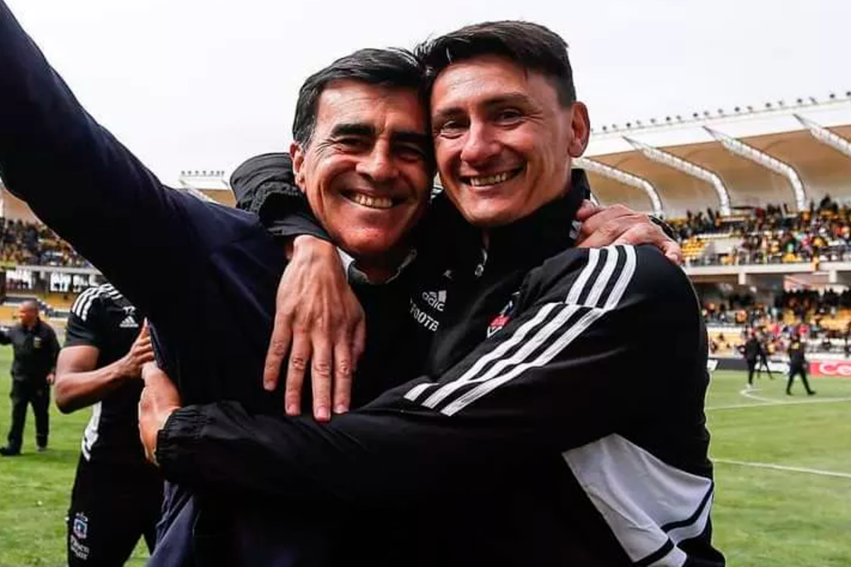 Gustavo Quinteros sonríe y abraza a uno de sus integrantes del cuerpo técnico tras conseguir el título del Campeonato Nacional 2022.