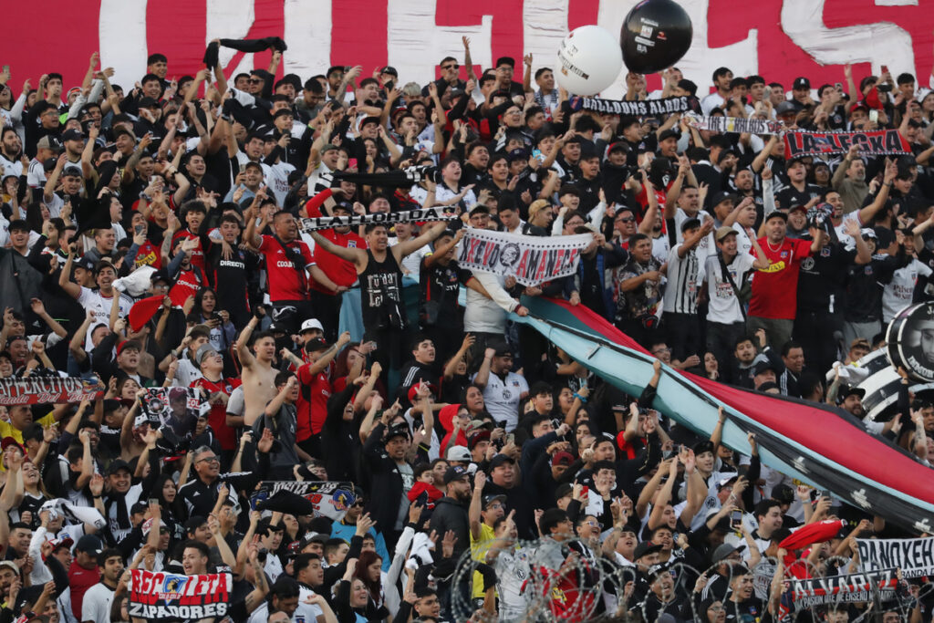 Hinchas de Colo-Colo alientan al primer equipo en el sector Arica del Estadio Monumental.