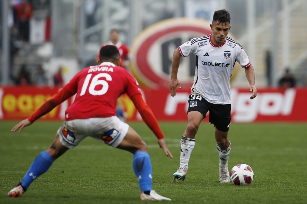 Vicente Pizarro con el balón, siendo marcado por Bryan Rovira en el partido de Colo-Colo vs Universidad Católica.