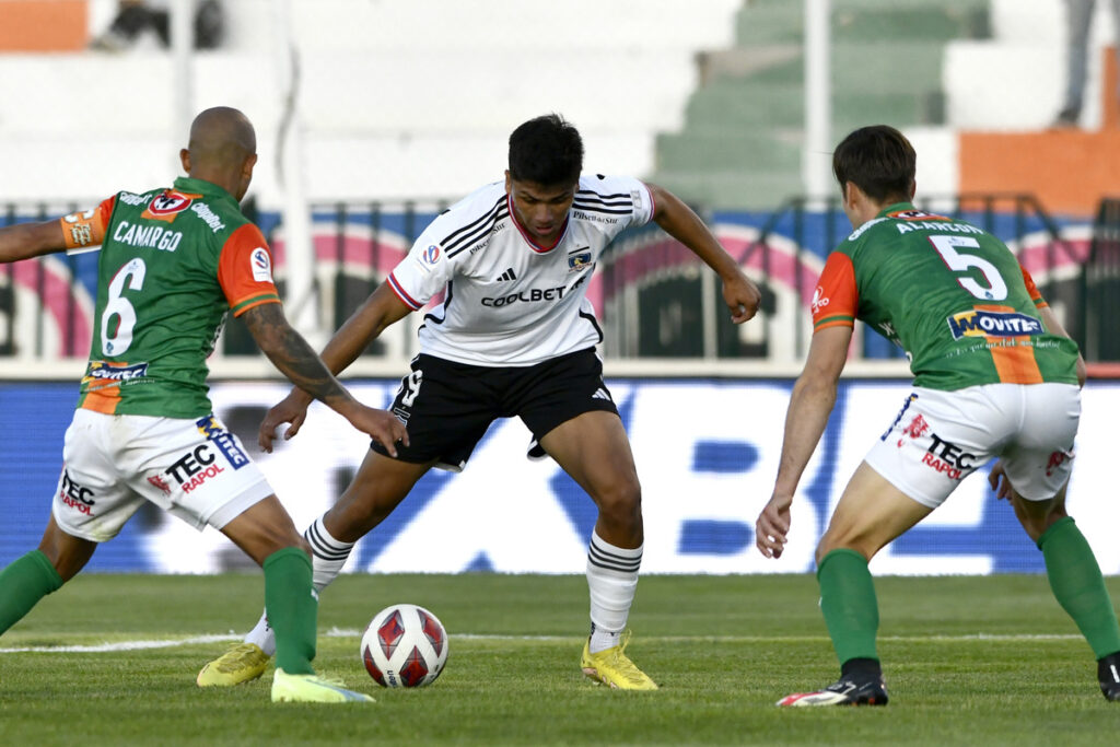 Damián Pizarro disputando un balón co. dos jugadores de Cobresal.