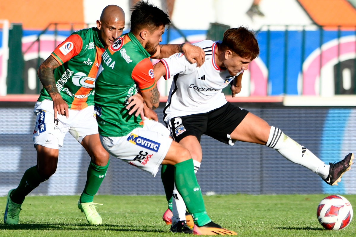 Leonardo Gil mantiene la posición del balón mientras es marcado de cerca por dos jugadores de Cobresal.