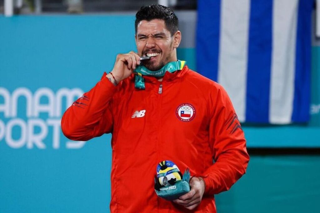 Thomas Briceño mordiendo su medalla de plata.