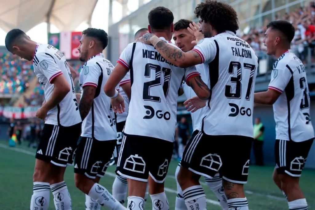 Futbolistas de Colo-Colo abrazados luego de anotar un gol ante Audax Italiano.