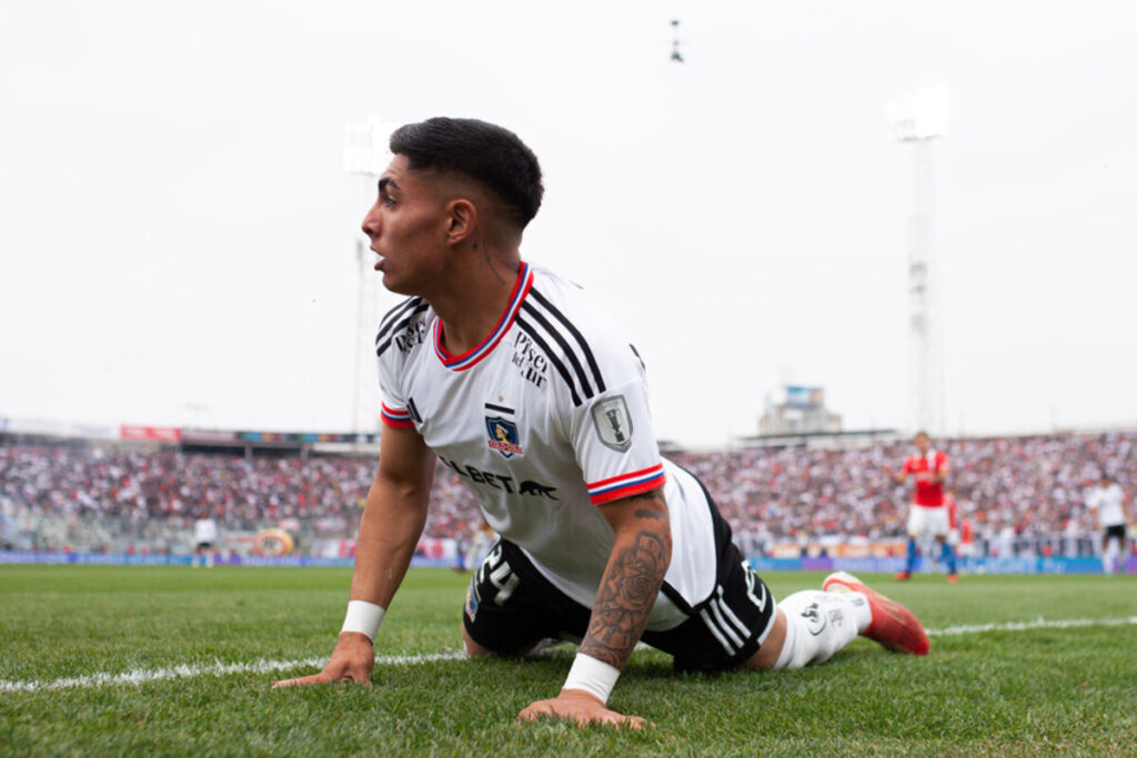 Jordhy Thompson de rodillas y con las manos puestas en el césped del Estadio Monumental en pleno partido de Colo-Colo durante la temporada 2023.