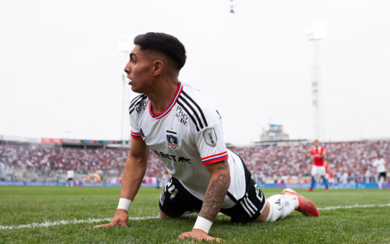 Jordhy Thompson de rodillas y con las manos puestas en el césped del Estadio Monumental en pleno partido de Colo-Colo durante la temporada 2023.