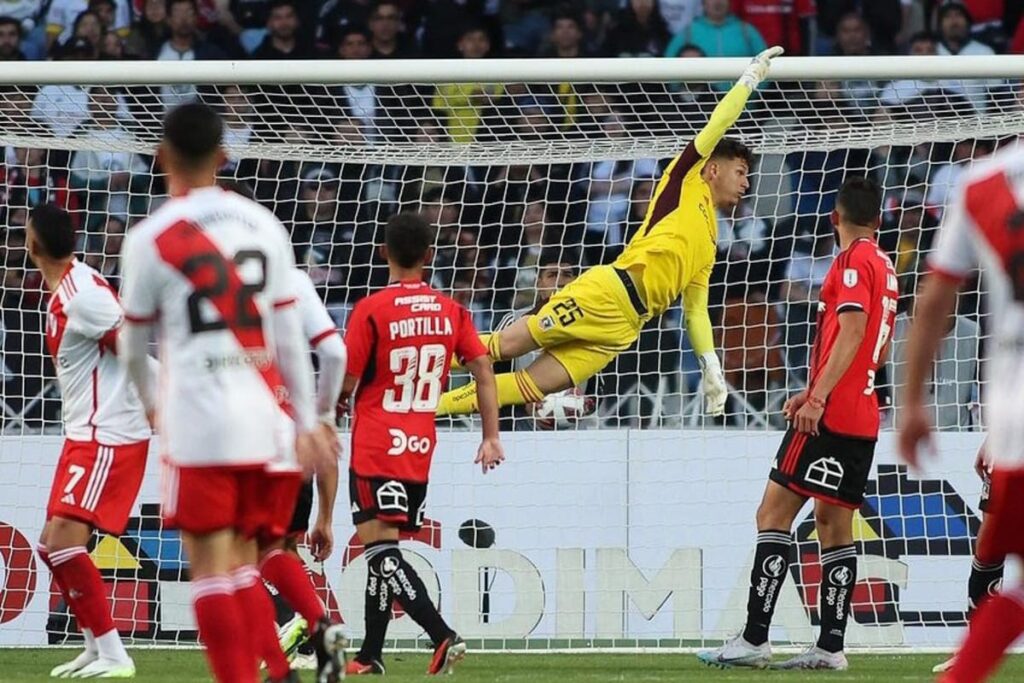 Martín Ballesteros en el aire durante el partido de Colo-Colo frente a River Plate.