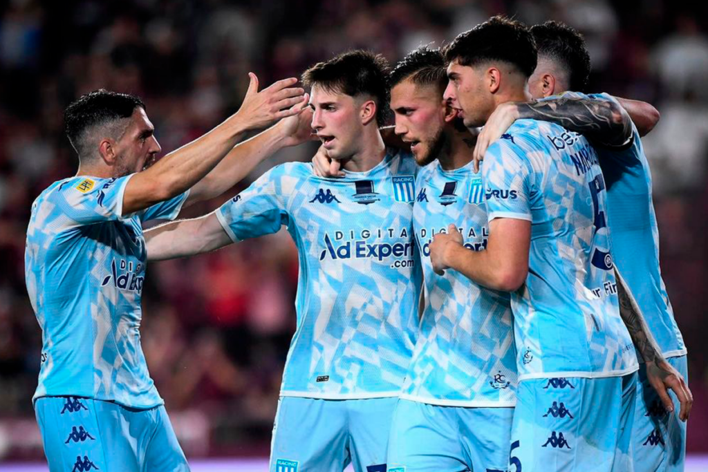 Futbolistas de Racing Club se abrazan y celebran un gol durante la temporada 2023.