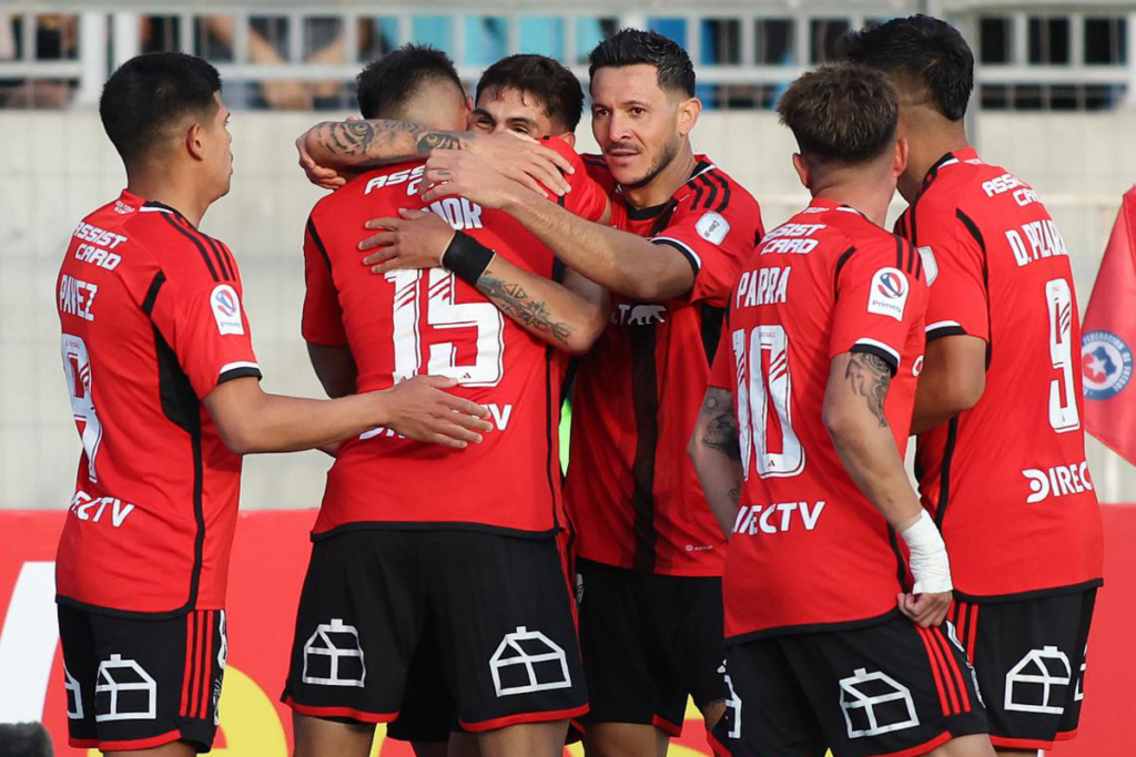 Futbolistas de Colo-Colo se abrazan y celebran un gol durante la temporada 2023.