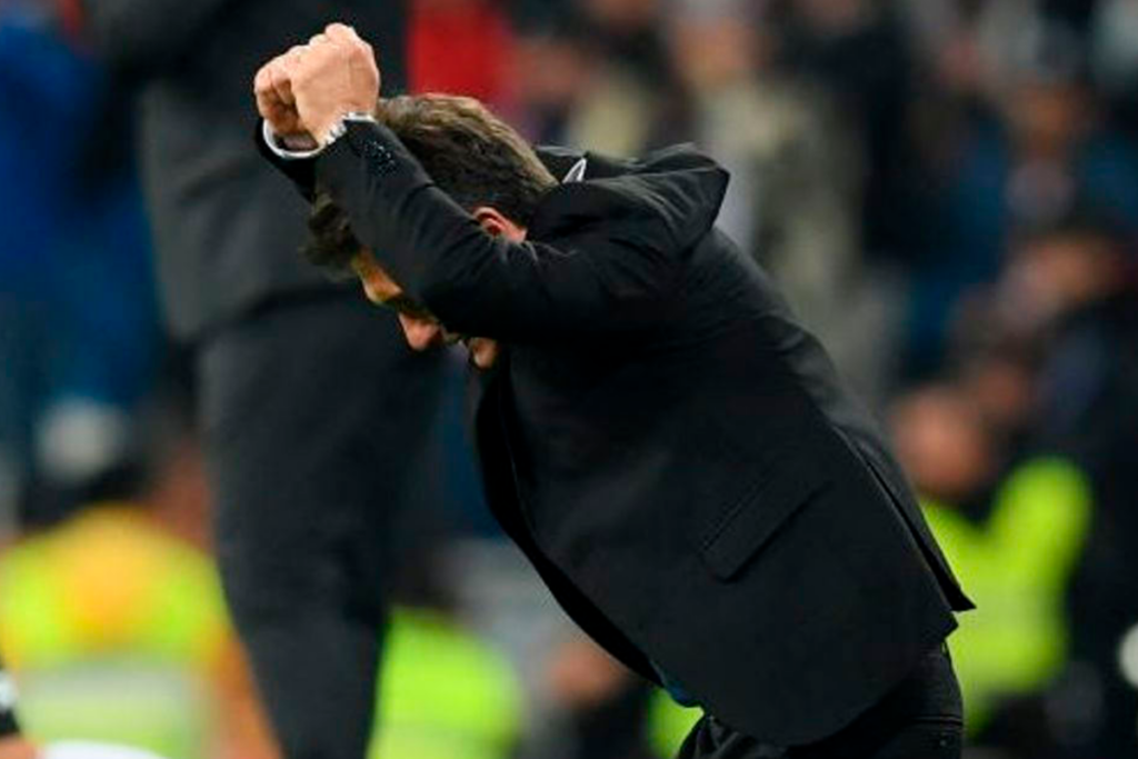 Guillermo Barros Schelotto con los puños celebra un logro en su rol de director técnico.