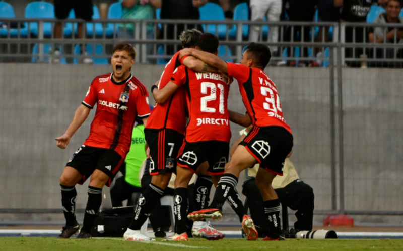 Futbolistas de Colo-Colo se abrazan para festejar un gol.