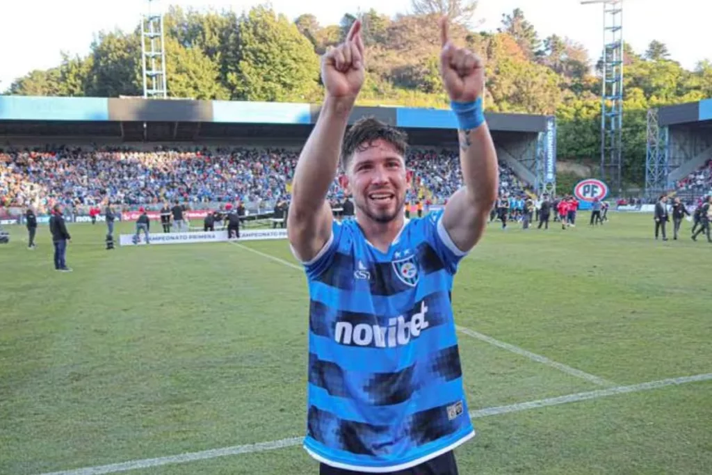 Felipe Loyola con los brazos levantados mientras usa la camiseta de Huachipato