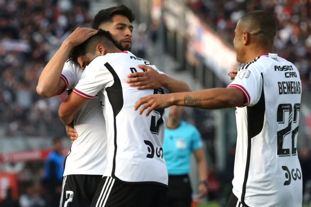 Jugadores de Colo-Colo abrazados festejando un gol