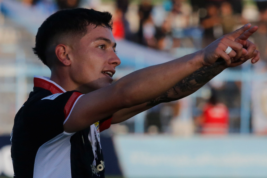 Cristián Zavala levanta su dedo derecho para apuntar un objetivo en pleno partido con la camiseta de Curicó Unido.