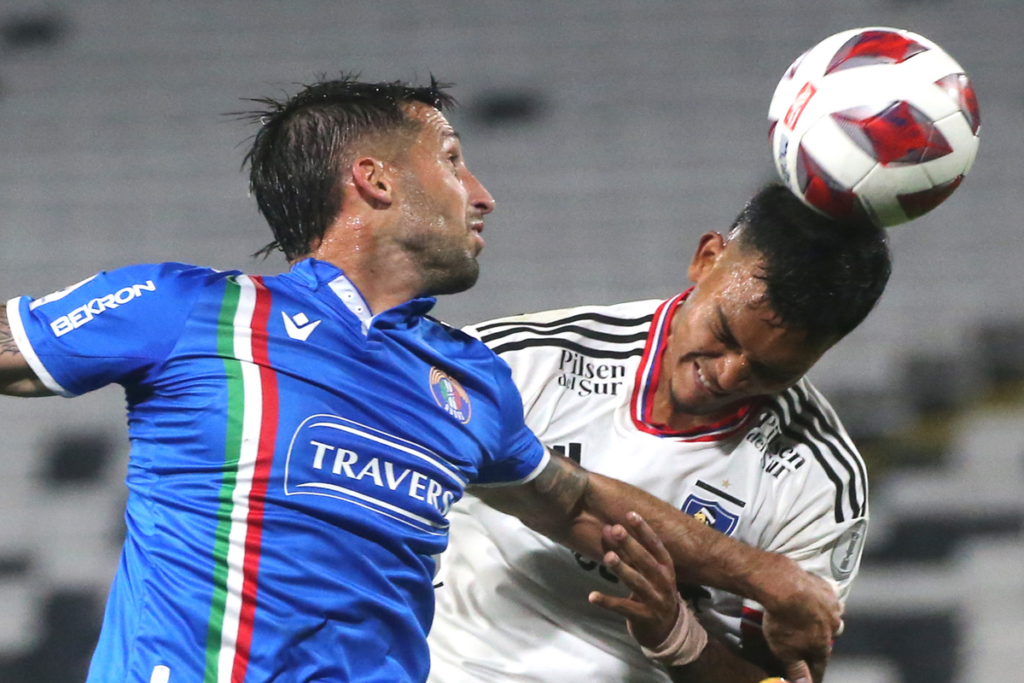 Gonzalo Sosa y Daniel Gutiérrez disputando un balón aéreo durante un partido de Colo-Colo y Audax Italiano durante la temporada 2023.