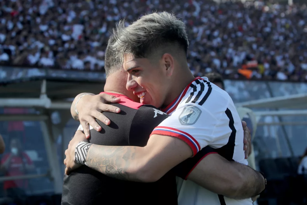 Carlos Palacios abraza a Ronald Fuentes en pleno partido entre Colo-Colo y Unión Española durante la temporada 2023.