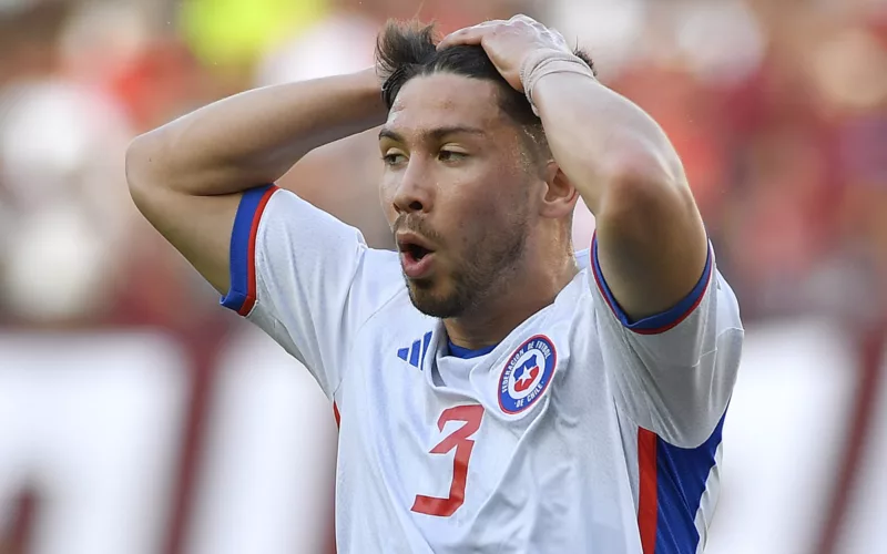 Felipe Loyola agarrándose la cabeza con sus manos mientras disputa un partido por la Selección Chilena.