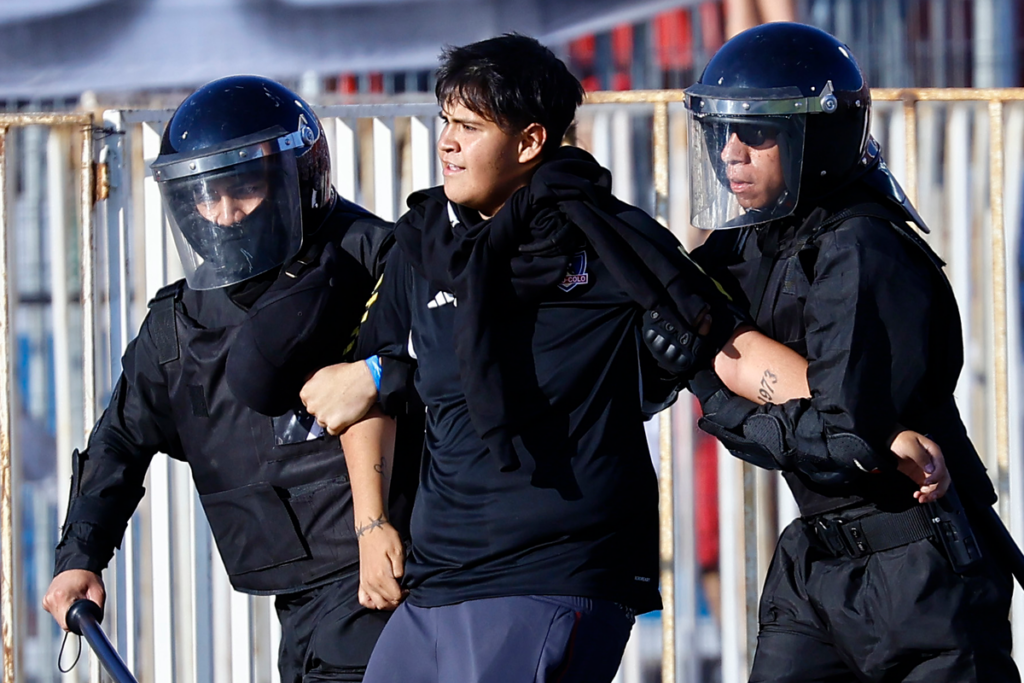 Hincha de Colo-Colo es detenido por dos uniformados tras serios incidentes en la Supercopa 2024.