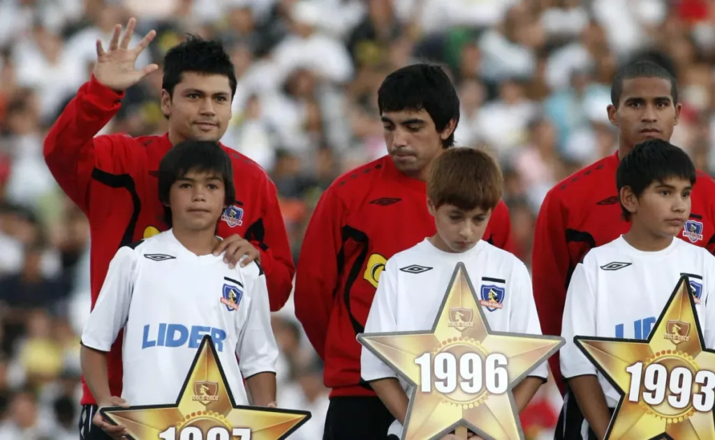 Yerson Opazo levanta su mano en plena presentación con el plantel de Colo-Colo en la clásica Noche Alba.