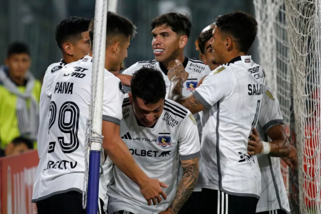 Futbolistas de Colo-Colo sonríen y se abrazan para celebrar un gol en la Copa Libertadores 2024