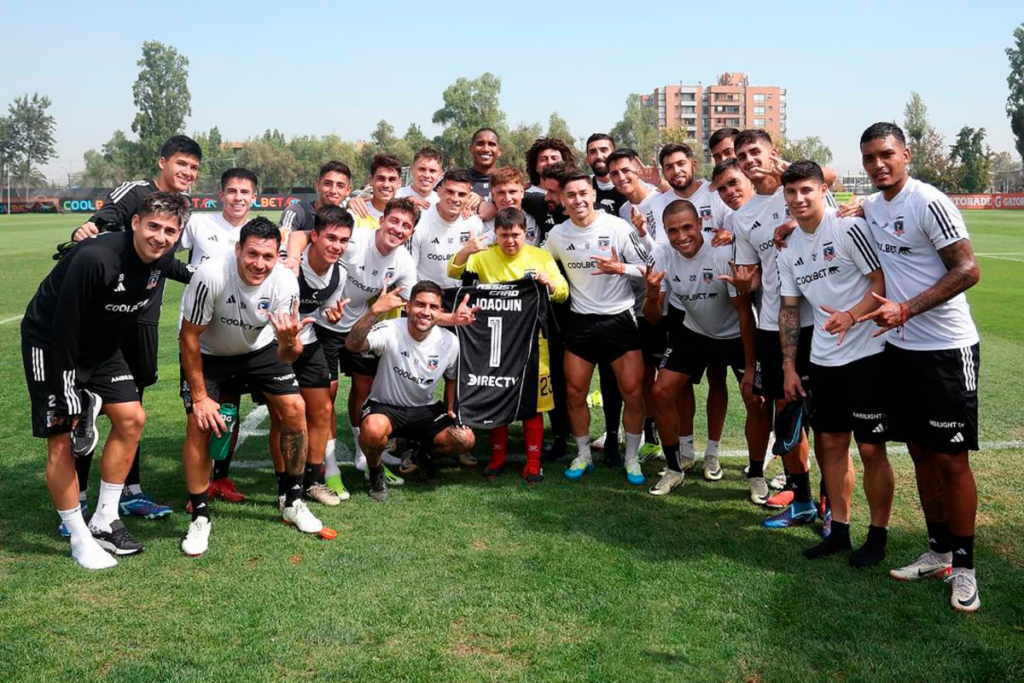 Plantel de Colo-Colo posa junto a un hincha de la Escuela Monumental, Joaquín, quien tiene Síndrome de Down.