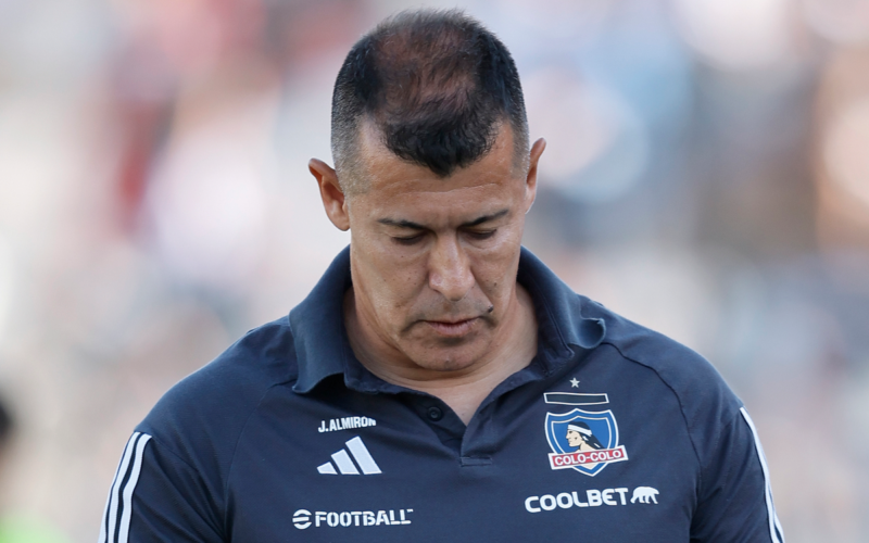 Jorge Almirón con cara triste y la mirada cabizbaja en pleno partido dirigiendo a Colo-Colo durante la temporada 2024.