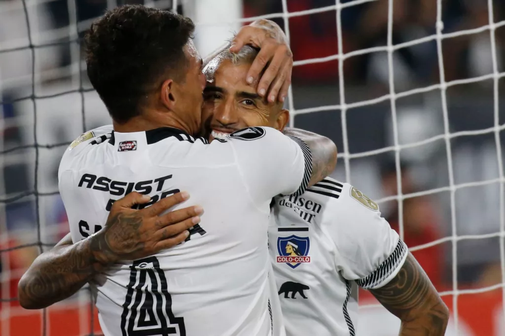 Primer plano a Alan Saldivia y Arturo Vidal celebrando un gol con la camiseta de Colo-Colo.