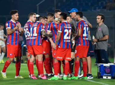 Futbolistas de Cerro Porteño se reúnen al borde del terreno de juego para recibir una instrucción de su director técnico.