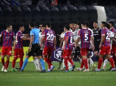 Futbolistas de Cerro Porteño rodean al árbitro Facundo Tello y reclaman un cobro, mientras que los deportistas de Colo-Colo miran atentos a la situación.