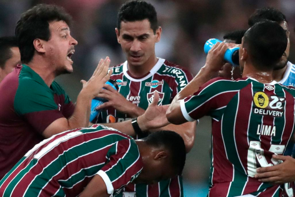 Futbolistas de Fluminense se reúnen y reciben una instrucción de su entrenador en pleno partido.