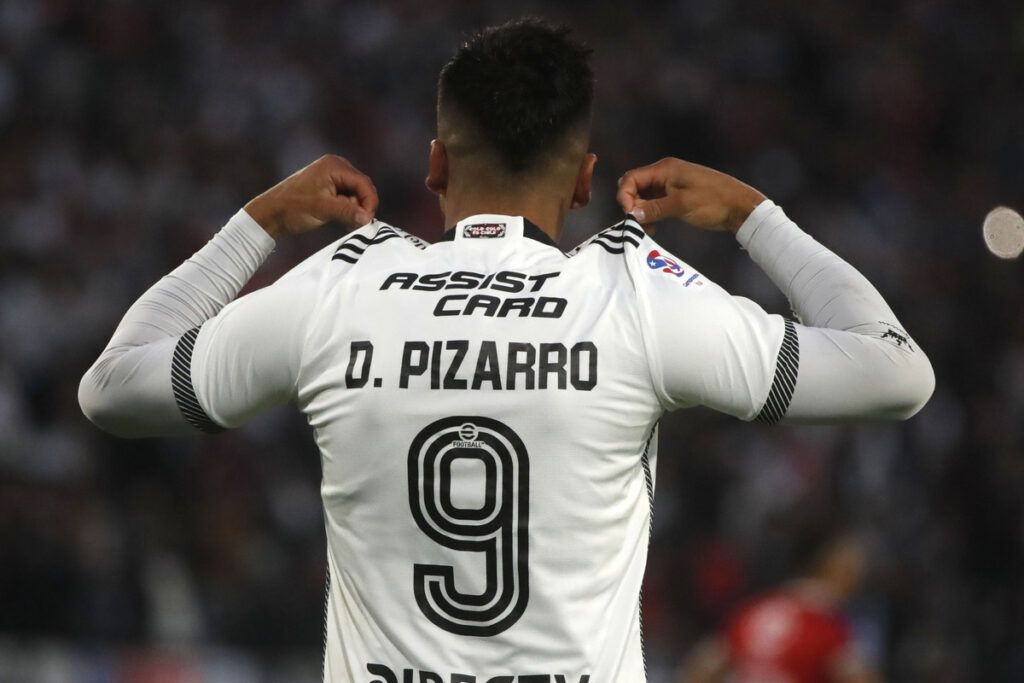 Damián Pizarro mostrando la camiseta de Colo-Colo con su apellido y su número.