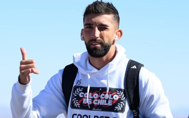 Primer plano a Emiliano Amor con polerón de Colo-Colo y un pulgar arriba.